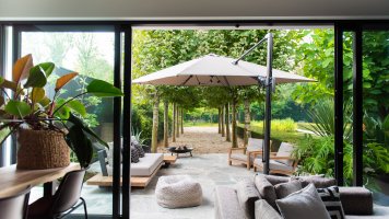 Luxuriöse Terrassen mit Gartenmöbeln und Fliesen XXL. Grüne Jahreszeit entwerfen. Urheberrecht: Studio Struis.