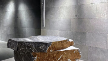 Badezimmer mit Waschbecken aus Naturstein und Wandsteinen.