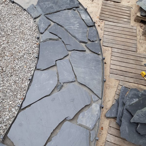 Bau eines Gartenwegs mit schwarzen Steinplatten