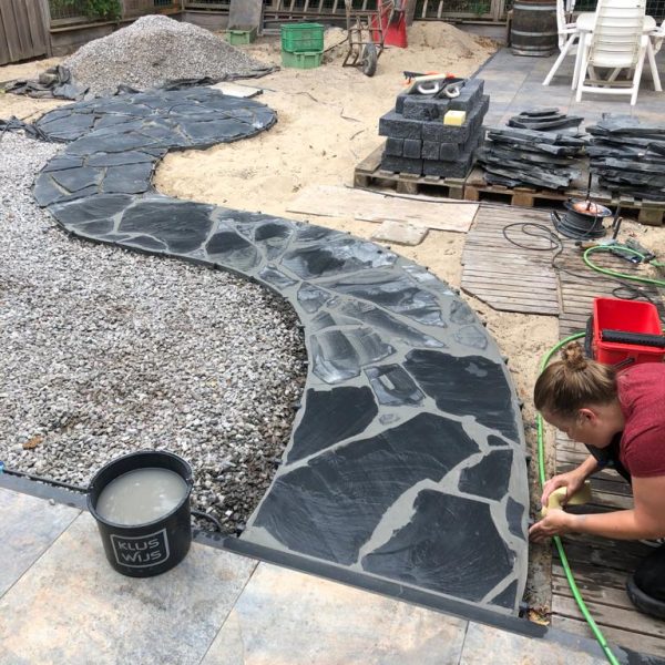 Bau eines Gartenwegs mit schwarzen Steinplatten
