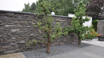 Stein rutscht an Gartenmauer