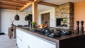 Steinstreifen in der modernen Küche mit Holzbalken. Foto von De Rooy Metaaldesign