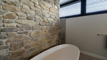 Wandbadezimmer mit Steinstreifen.